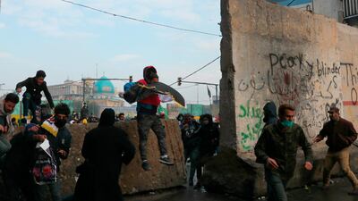 Anti-government protesters run during clashes with security forces in Baghdad. AP Photo