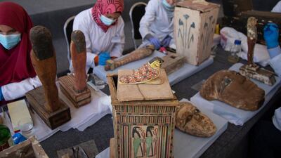 Archaeologists work on artefacts as sarcophaguses are presented to the media near the newly discovered burial site at Saqqara Necropolis in Giza. EPA