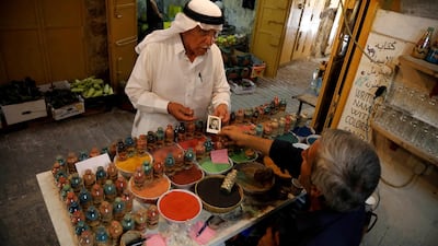A Palestinian man shows his picture to Al-Awawda as he commissions a sand artwork bearing his likeness. Reuters