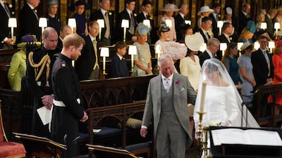 Prince Harry looks at his bride, Meghan Markle, as she arrives accompanied by Prince Charles during their wedding in St George's Chapel at Windsor Castle in Windsor. Jonathan Brady / Getty Images