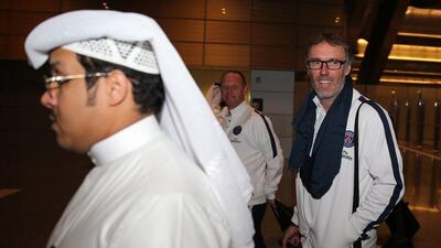 Paris Saint-Germain's French head coach Laurent Blanc (R) looks on upon his arrival in the Qatari capital Doha on December 27, 2015, with his players to take part in training camp. AFP PHOTO / STR == QATAR OUT ==