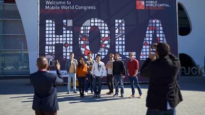 People take pictures in front of a banner at the Mobile World Congress in Barcelona, Spain. Manu Fernandez / AP Photo