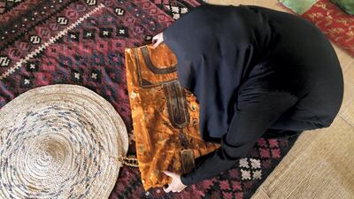 Umm Mohammed Al Kaabi displays a jalabiya with telli embroidery. Reem Mohammed / The National