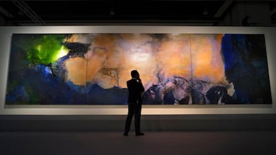 A man stands in front of the largest-ever painting 'Juin-Octobre 1985' by Chinese French artist Zao Wou-Ki. Vincent Yu, File / AP photo