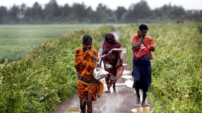 Indian villagers brave strong winds and rain to reach a cyclone centre in Podampeta, eastern India. Biswaranjan Rout / AP