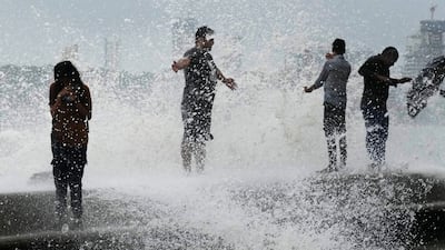 People enjoying the waves on the coast in Mumbai. AP Photo