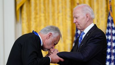 Father Karloutsos kisses Mr Biden's hand at the ceremony. AP