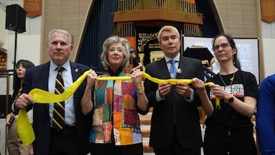 From left, Col Kemp, Lipman, London and businesswoman Nivi Feldman hold a yellow ribbon to show support for the hostages in Gaza. PA