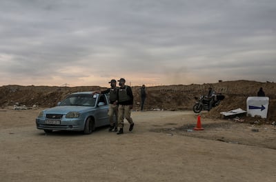 Foreign security personnel check the details of displaced Palestinians travelling to northern Gaza. EPA