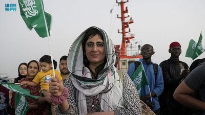 A woman waves a Saudi flag in Jeddah after being evacuated by the kingdom. Reuters