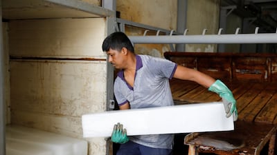 A workman shifting ice blocks during the heatwave in Iraq.