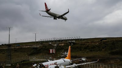A plane descends to land, as soldiers guard the wreckage of a plane operated by Pegasus Airlines after it skidded Wednesday off the runway at Istanbul's Sabiha Gokcen Airport, in Istanbul. AP Photo