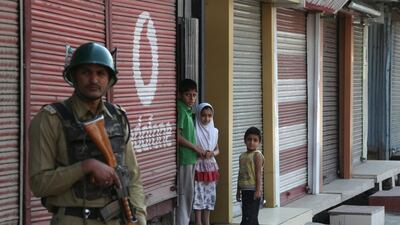Kashmiri children look on as an Indian paramilitary soldier stands guard during restrictions in the downtown area of Srinagar, the summer capital of Indian-controlled Kashmir, on June 18, 2015. Farooq Khan/EPA