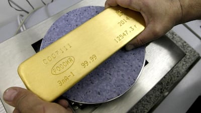 An employee weighs an ingot of 99.99 per cent pure gold at the Krastsvetmet plant in Siberia. Ilya Naymushin / Reuters