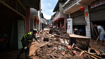 Locals clean up silt and garbage in aftermath of flooding in Yantouzhai, Hunan on Sunday. EPA