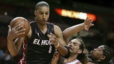 The Chicago Bulls' Joakim Noah, second from right, tries to get the ball from the Miami Heat's Jamario Moon during the first half of their NBA game on Monday, which Miami edged in double overtime.