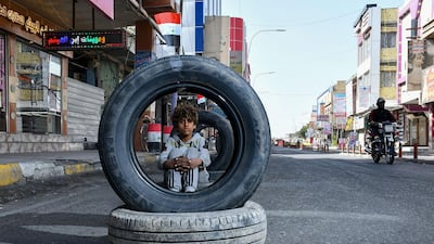 An Iraqi youth poses for a picture with tyres in the southern Iraqi city of Nasiriyah. AFP