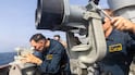 US naval personnel onboard the guided-missile destroyer USS Higgins monitor a nearby vessel in the Middle East. Photo: Centcom
