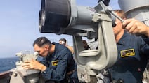 US naval personnel onboard the guided-missile destroyer USS Higgins monitor a nearby vessel in the Middle East. Photo: Centcom