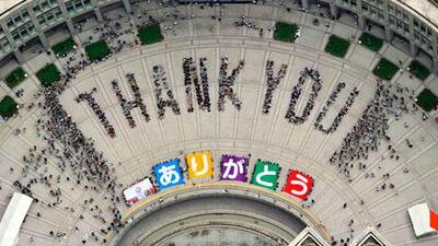 People sitting in formation of the words ‘thank you’ in Tokyo on Sunday after Saturday’s vote. Kyodo / Reuters