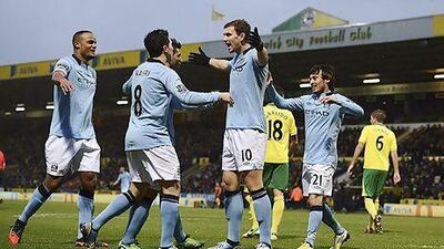 Manchester City's Edin Dzeko (No 10) celebrates with his teammates Sergio Aguero, left, and David Silva.