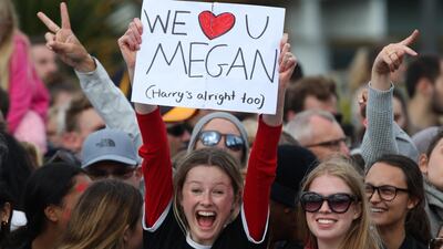 Fans watch and hold up signs as Prince Harry and Meghan arrive at Government House on October 28, 2018 in Wellington. Getty Images