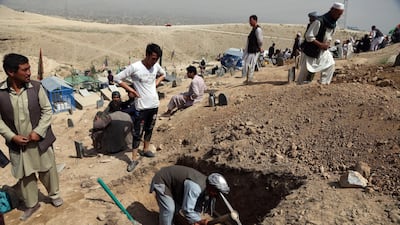 Afghan men prepare the graves for the victims of the bombing that targeted a training class in a private building in the Shiite neighborhood of Dasht-i Barcha. AP