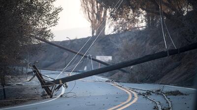 Burned and fallen power poles lay on a road during the 'Thomas Fire' which began overnight in Ventura, California. John Cetrino / EPA