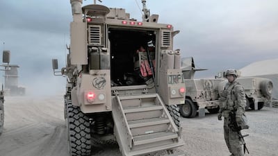 A US soldier standing next to a Mine Resistant Ambush Protected Vehicle (MRAP) on the Qayyarah air base. Florian Neuhoff for The National