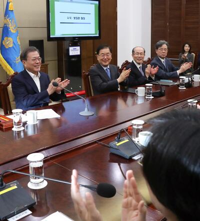 South Korean President Moon Jae-in, left, reacts after hearing the news that South Korean director Bong Joon-ho won four Academy Awards. EPA