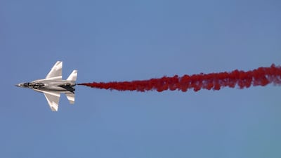 A Chinese Hongdu JL-10 (L-15) supersonic advanced jet trainer and light combat aircraft releases coloured smoke while performing aerial manoeuvres during the 2021 Dubai Airshow. AFP