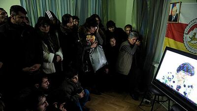Supporters of South Ossetia's presidential candidate Alla Dzhioyeva watch a television broadcast of the election commission's statement in the Georgian territory. Mikhail Mordasov / AFP Photo