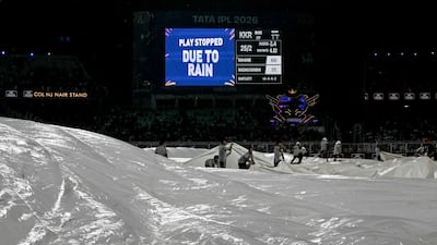 Groundsmen cover the pitch as rain halts play during the IPL match between Kolkata Knight Riders and Punjab Kings at the Eden Gardens. AFP