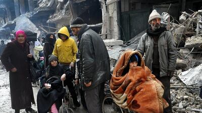 In this photo from February 4, 2014, Yarmouk residents wait at the gate of the camp to receive aid supplies from the United Nations. SANA, File/AP Photo
