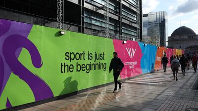 Pedestrians walk past Commonwealth Games branding in the city centre. Getty Images