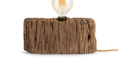 A bare bulb attached to a well-worn piece of wood are the features of this lamp from Flamant