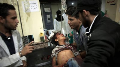 Syrian medics hold a child who died from government forces shelling at the Dar al-Shifa hospital in Aleppo, Syria.