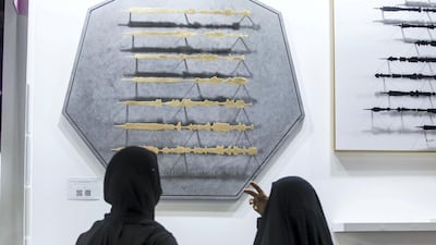 Visitors looking at an artwork by Syrian artist Sara Alharbali. Leslie Pableo / The National
