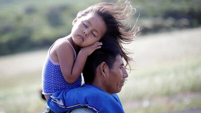 Rosendo Noviega, from Guatemala, carries his daughter Belinda Izabel as they travel in a caravan of Central American immigrants headed to the United States. Reuters