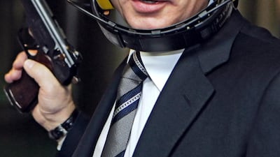 Putin holds a pistol during his visit to headquarters of the Russian General Staff's Main Intelligence Department in Moscow on November 08, 2006. AFP