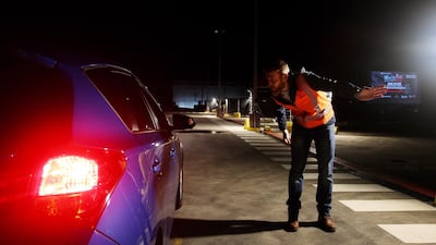 A staff member directs a guest to a parking spot at the pop-up 'Mov'In Car' Drive-in cinema cafe on its opening night at the Entertainment Quarter car park in Sydney, Australia. Bloomberg