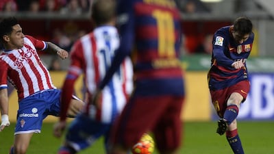Barcelona’s Argentinian forward Lionel Messi (R) kicks the ball to score a goal during the Spanish league football match Real Sporting de Gijon vs FC Barcelona at El Molinon stadium in Gijonon 2016. AFP PHOTO / MIGUEL RIOPA