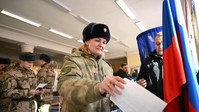 A service member casts her ballot in Russia's presidential election in Moscow on March 15, 2024. (Photo by NATALIA KOLESNIKOVA / AFP)