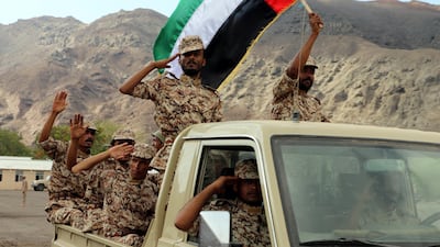 Yemeni soldiers trained by Emirati troops wave a UAE flag during combat training. EPA