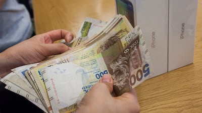 An Apple member of staff counts a customer's money as they pay for a new iPhone X at an Apple store in Hong Kong, China, on November 3, 2017. Alex Hofford / EPA