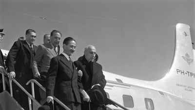 the former Iranian prime minister Mohammad Mosaddeq, right, escorted down the steps of a plane. In a coup supported by the British and US governments, Mosaddeq was removed from power on August 19, 1953. AFP / Getty