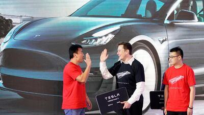 Tesla chief executive Elon Musk with China-made Model 3 vehicle owners during a delivery event in Shanghai in January. Reuters