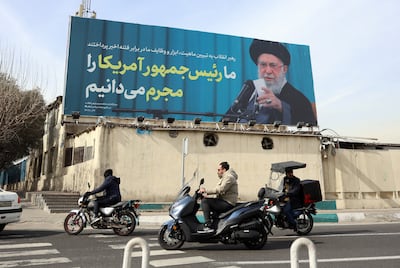 Iranians pass a billboard in Tehran showing Iran's supreme leader Ayatollah Ali Khamenei and a sentence reading in Persian: 'We know US president as a criminal following anti-government protests'. EPA