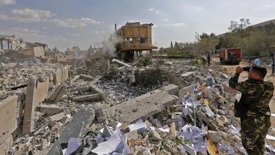 A Syrian soldier takes a picture of the wreckage of a building described as part of the Scientific Studies and Research Centre (SSRC) compound in the Barzeh district, north of Damascus, during a press tour organised by the Syrian information ministry, on April 14, 2018. The United States, Britain and France launched strikes against Syrian President Bashar al-Assad's regime early on April 14 in response to an alleged chemical weapons attack after mulling military action for nearly a week. Syrian state news agency SANA reported several missiles hit a research centre in Barzeh, north of Damascus, "destroying a building that included scientific labs and a training centre". AFP PHOTO / LOUAI BESHARA