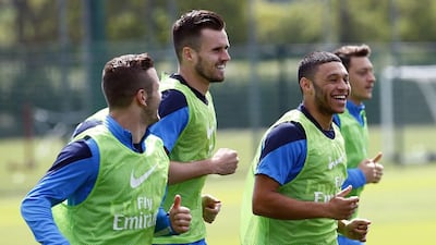 Arsenal midfielder Jack Wilshere, left, defender Carl Jenkinson, second left, forward Alex Oxlade-Chamberlain, second right, and midfielder Mesut Ozil, right, take part in Wednesday's training session ahead of the FA Cup final. Carl Court / AFP / May 14, 2014
